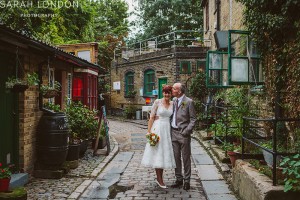 Couple kissing in cobbled street in Hackney city farm.